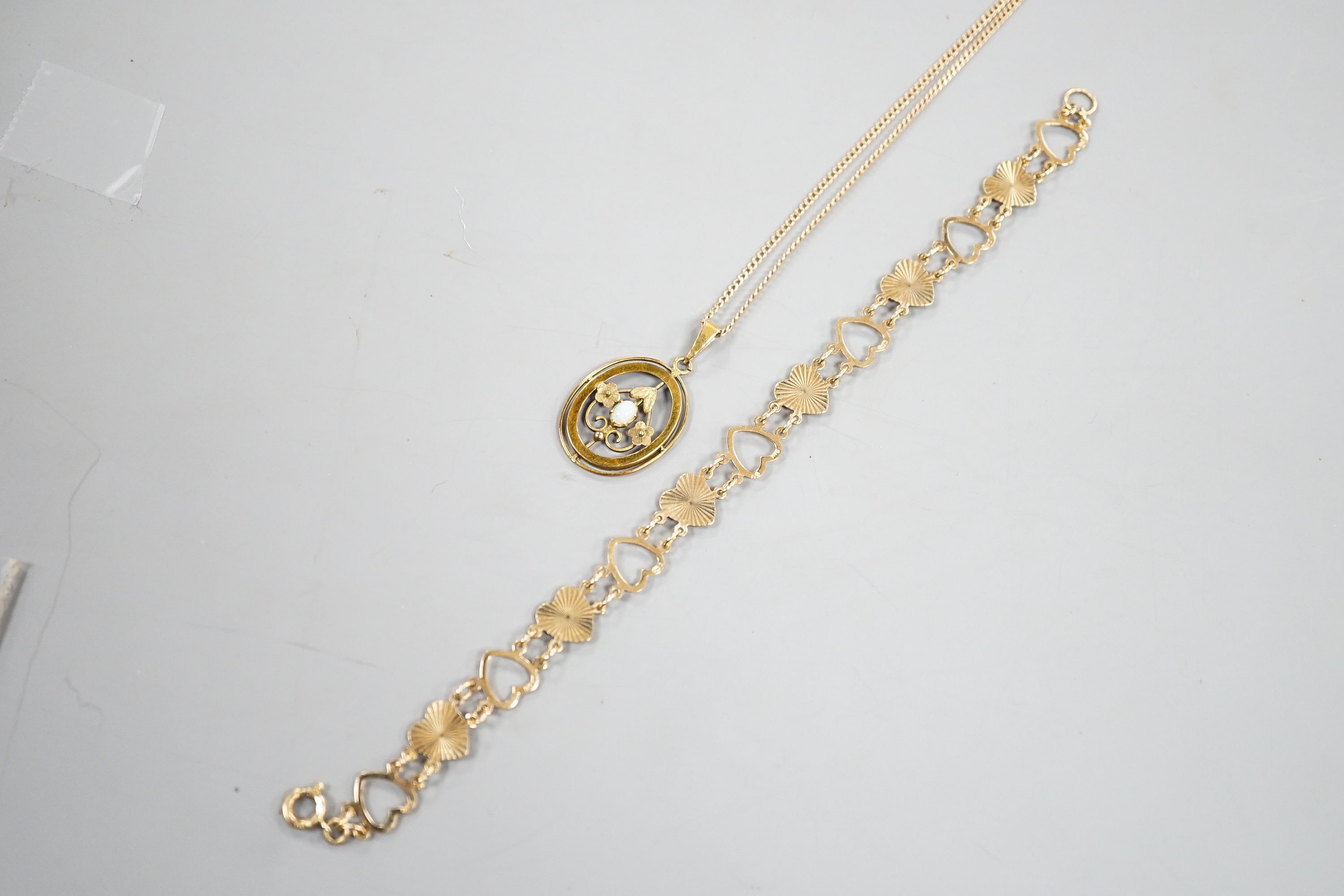 A 9ct and heart shaped link bracelet, 18cm and a yellow metal and opal pendant on a yellow metal chain